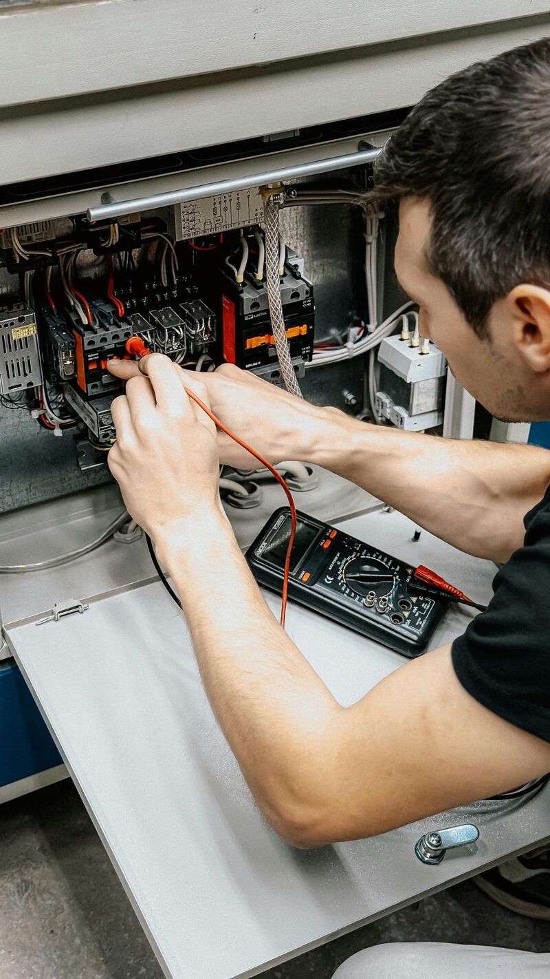 Electrician testing electrical panel with multimeter